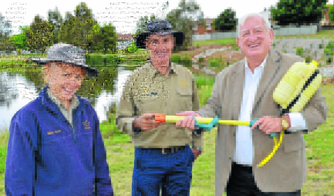 WET AND WILD: Orange City Council wetlands team members Maryanne Smith and David Shea check out mayor John Davis’ water pistol technique in preparation for Sunday’s Wild at the Wetland Day at the Somerset Park .