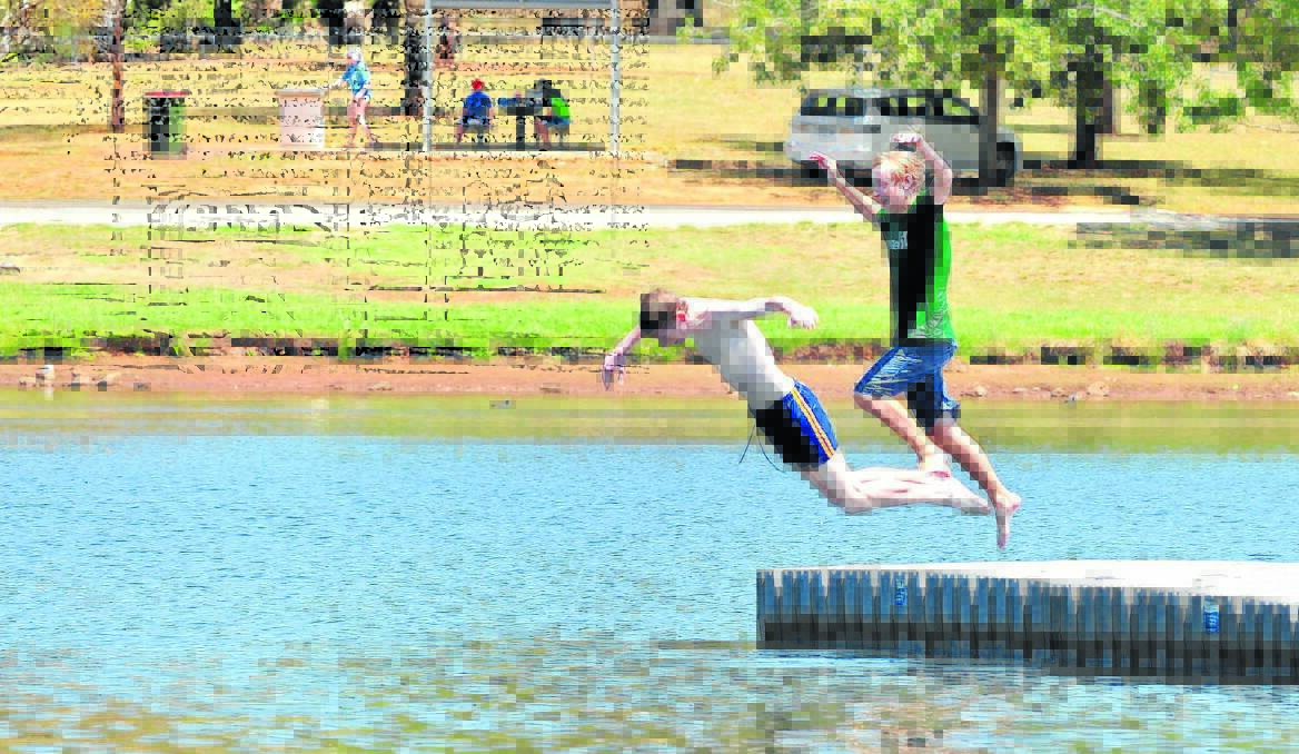 Myles and Tobias Thomas dive in to keep cool at Lake Canobolas. Photo: JUDE KEOGH 0116lake3