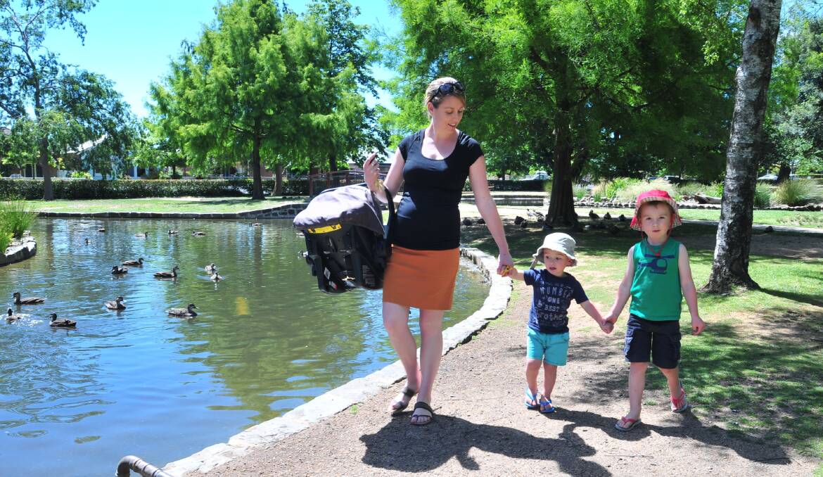 Carrie, Sam and Archie Cox visit the duck pond yesterday. Photo: JUDE KEOGH 