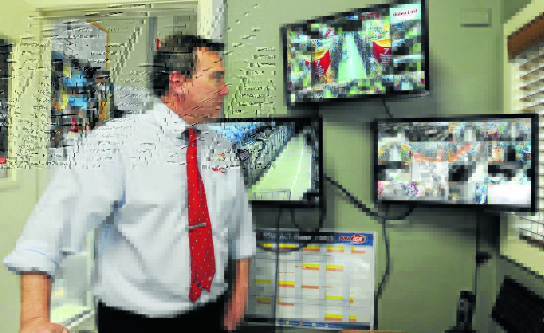 HAWK-EYE: Ashcrofts Supa IGA Peisley Street store manager Blaise Linklater monitors the 48 security cameras arranged around the store to deter would be theives. Photo: STEVE GOSCH 								           0103sgiga1