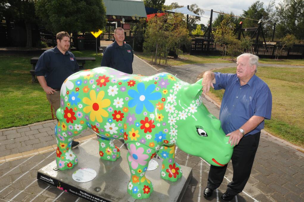 A HUGE JOB: Kennards' Luke Pearman and Craig McMahon with Orange City Council mayor John Davis unveil a new visitor to the city yesterday. Photo: STEVE GOSCH                                                                                                             0204sgrhino3