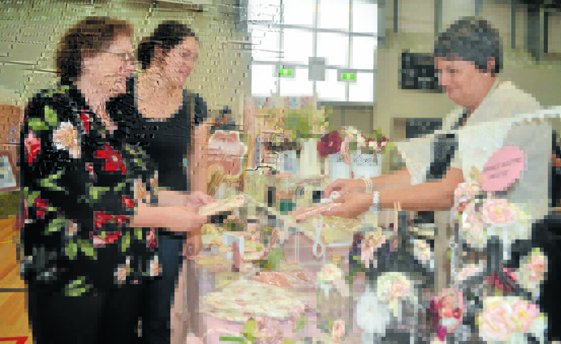 TIMELESS VINTAGE: Mother-of-the-bride Rhonda Redenbach and her daughter bride-to-be Esther get advice from Tracey Tullier of Primrose Vintage Lace and Trim at yesterday’s Bridal Expo. Photo: CLARE COLLEY 	              0224ccbridal3