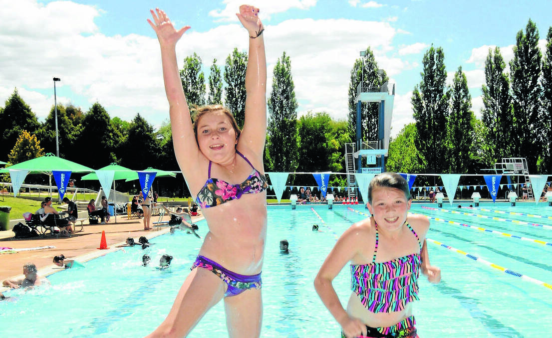 ORANGE: Lylah Baker and Georgie Drain were jumping for joy over free pool entry on the first day of summer. Swimmers enjoyed a barbecue as well as a dip. Photo: JUDE KEOGH 1201pool1