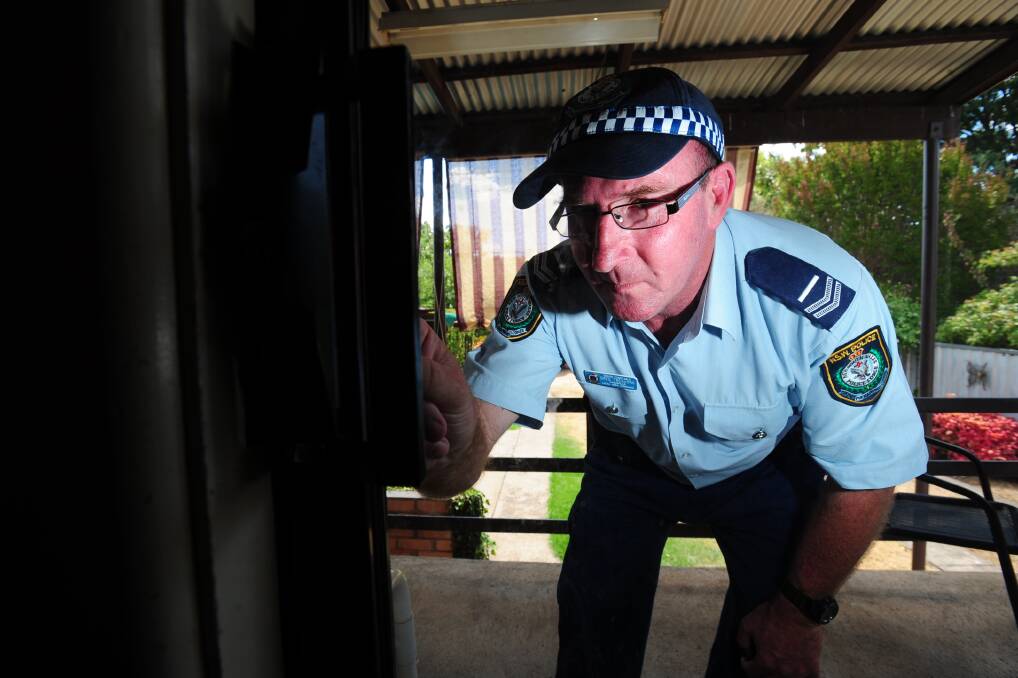 SAFETY FIRST: Crime Prevention Officer Greg Treavors inspects a lock. Photo: STEVE GOSCH