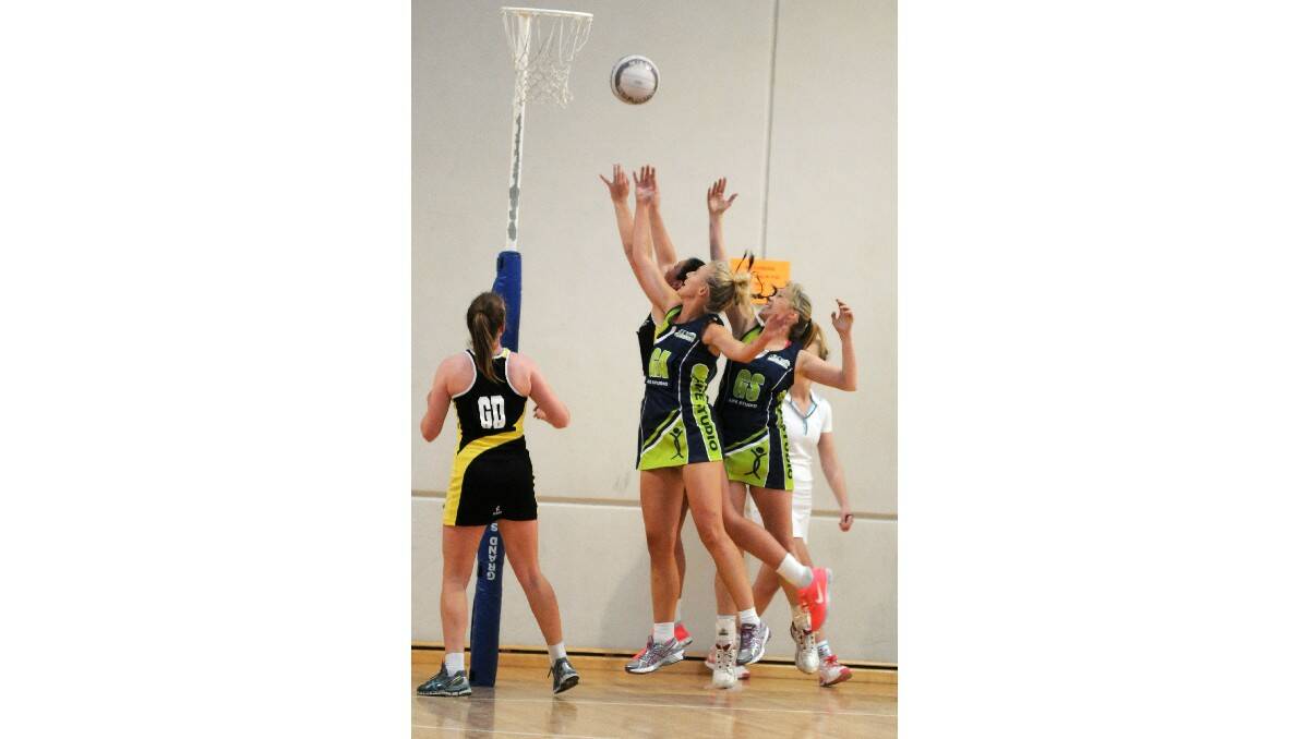 UP: Netball players leap all at once for the ball.