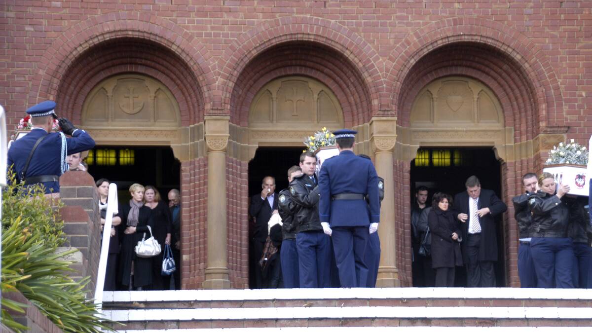 DARKEST OF DAYS: The caskets of Shelly Walsh's mother and two children are taken from the church on the day of their funeral in 2008, days after the horrifying triple murder which shocked the Cowra community.