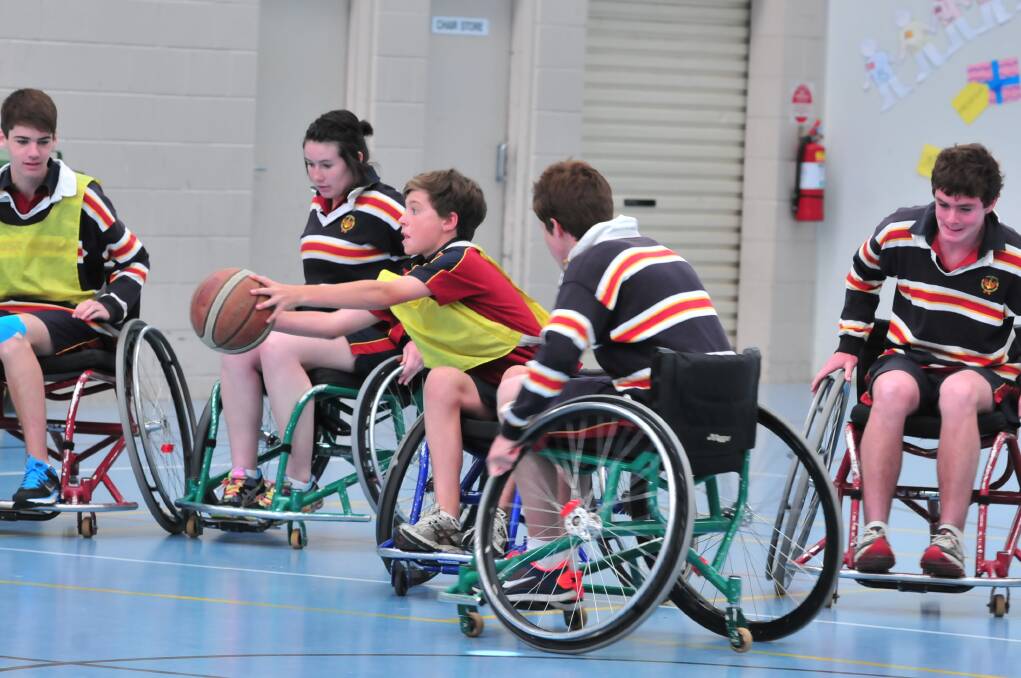 HOLDING COURT: James Sheahan Year 9 student Tom West took to the court on Wednesday in a game of wheelchair basketball under the instruction of Wheelchair Sports NSW Roadshow instructor John Wade. Photo: JUDE KEOGH
