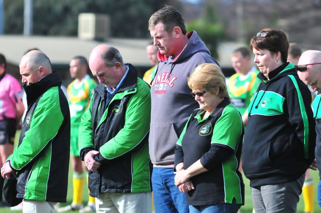 RESPECT: Darren Britt and the CYMS old boys observe a minute's silence before a game. Photo: JUDE KEOGH