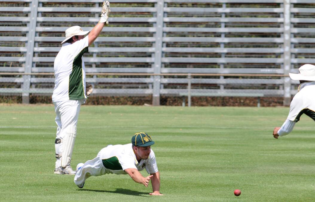 Orange CYMS' Nick Garton dives to stop the ball as keeper Adam Smith appeals for a Centrals' wicket in ODCA first grade action at Wade Park on Saturday. Photo: STEVE GOSCH