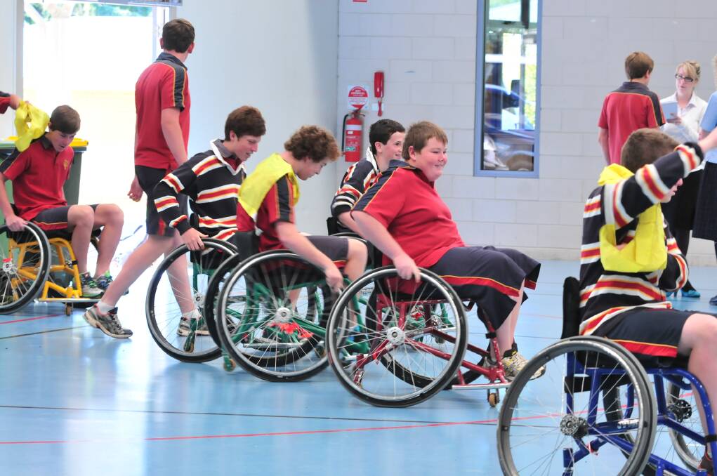 HOLDING COURT: James Sheahan Year 9 students take to the court in a game of wheelchair basketball under the instruction of Wheelchair Sports NSW Roadshow instructor John Wade. Photo: JUDE KEOGH