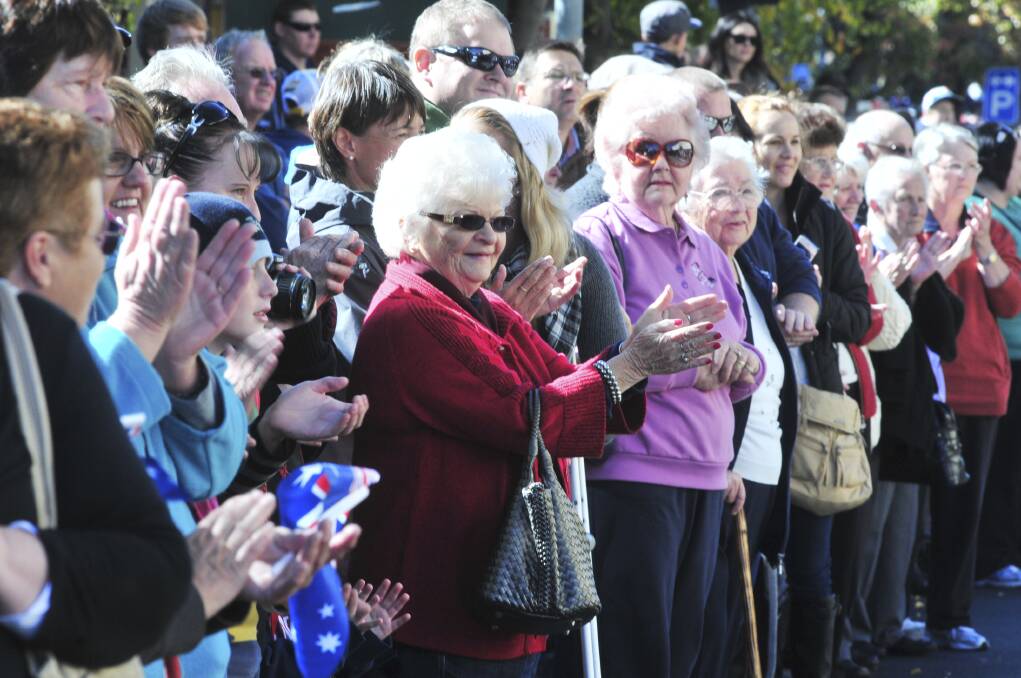 PROUD DAY: The crowds applaud those in the ANZAC Day march. Photo: JUDE KEOGH