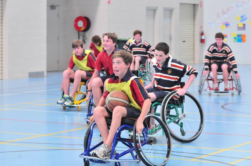 HOLDING COURT: James Sheahan Year 9 student Tom West took to the court on Wednesday for a game of wheelchair basketball under the instruction of Wheelchair Sports NSW Roadshow instructor John Wade. Photo: JUDE KEOGH