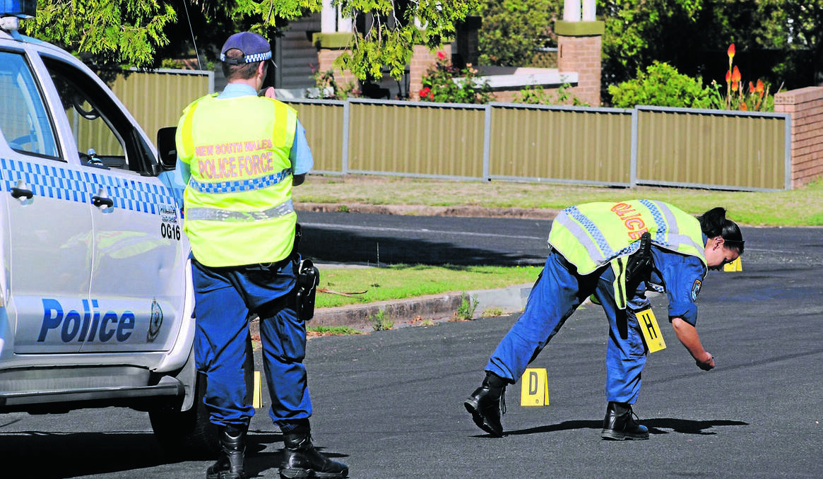 ORANGE: A FORENSIC team establish a crime scene on the corner of Icely Road and Allenby Road after two people were allegedly shot at during a robbery. Photo: STEVE GOSCH