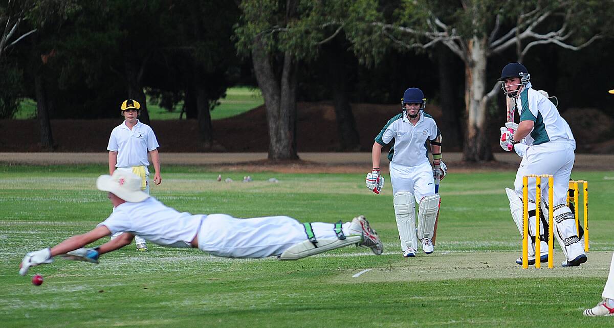 FULL STRETCH: Keeper Hamish Sheehan dives for the ball. Batsman is Connor Slattery. 