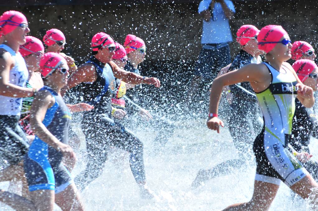 Competitors sprint into the water to start the race at Lake Canobolas on Saturday. Photo: JUDE KEOGH