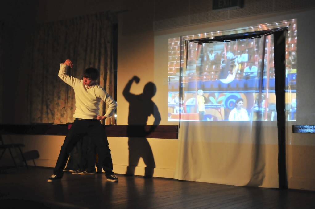 ON STAGE: Gerard poses as the screen plays footage of him competing as a gymnast in the Paralympics. Photo: JUDE KEOGH