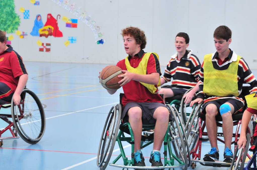 HOLDING COURT: James Sheahan Year 9 student Ryan Dillon took to the court on Wednesday in a game of wheelchair basketball under the instruction of Wheelchair Sports NSW Roadshow instructor John Wade. Photo: JUDE KEOGH