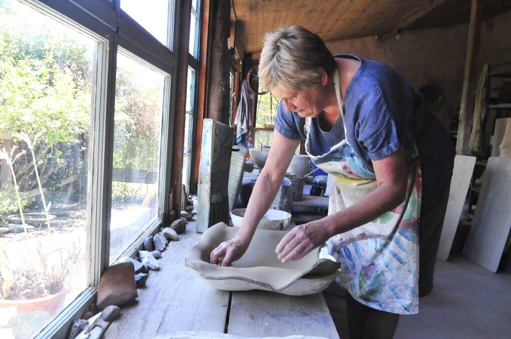 HARD AT WORK: Borenore artist Ros Auld prepares a piece for her exhibition in Queanbeyan, which opens in March. Photo: JUDE KEOGH  0115ros6