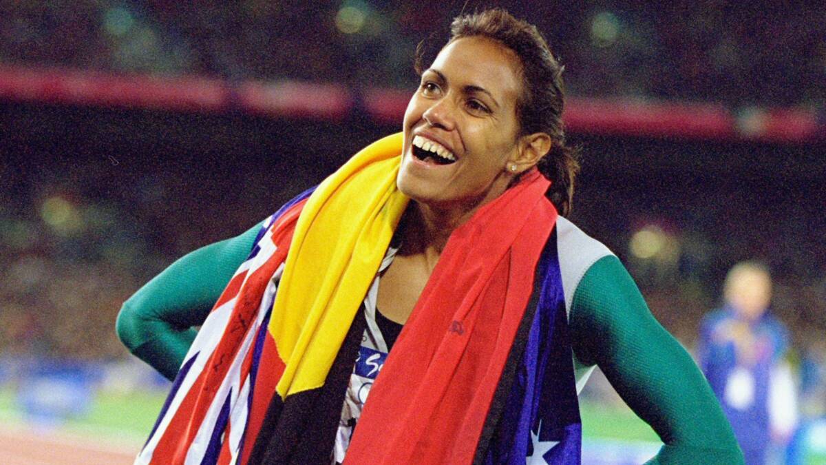 Cathy Freeman with the Australian and indigenous flags at the Sydney Olympics.