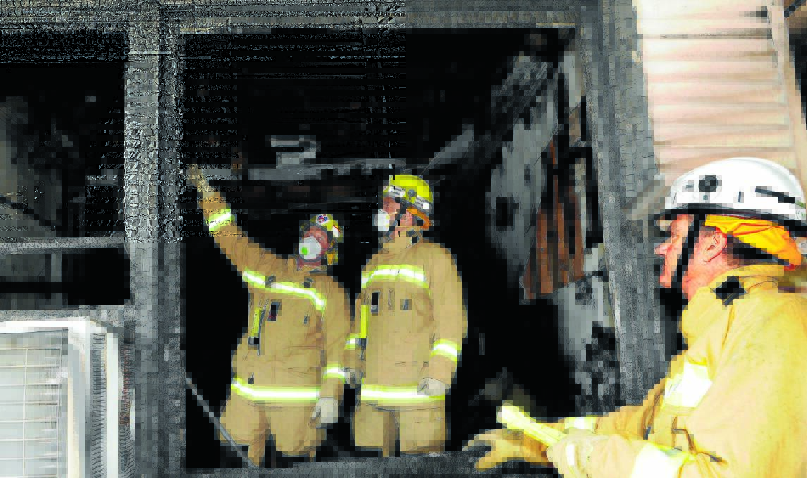 EXAMINING THE SCENE: Firefighters Mal Bird and Timothy Dungate of Bathurst Fire and Rescue NSW with Inspector Steve Knight at the scene of Thursday night's fire. Photo: PHILL MURRAY                                                                                                                                                                                          011014pfire1