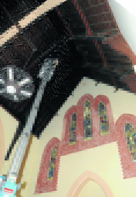 TALL ORDER: Orange photographer Robert Bruce goes to great lengths to preserve the stained glass windows at St Joseph’s Church. Photo: LUKE SCHUYLER     0120lschurch1