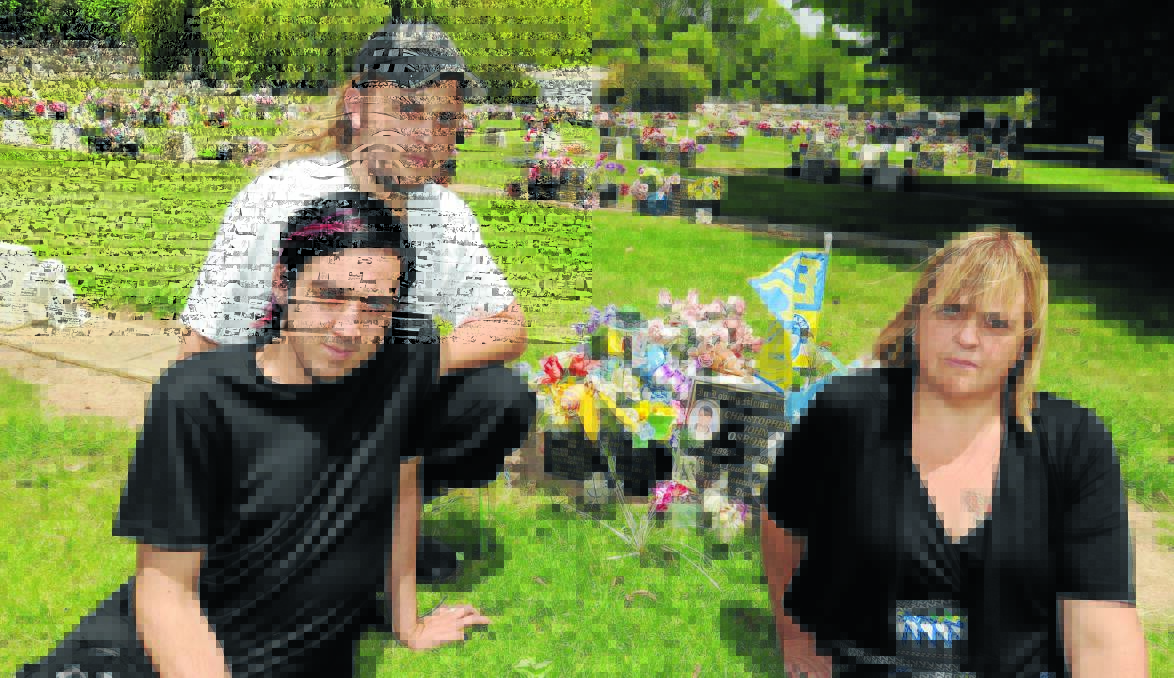 GRAVE THEFT: Debbie Osborne (right), with her sons Alexander and Brandon, says she can’t believe people would be so heartless as to steal from her son’s grave. Photo: STEVE GOSCH                                                                                                                                                           0911sg theft1