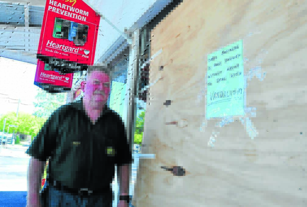 FED UP: March Street Pet Foods owner Peter Moad posted a message for vandals on his boarded-up front window. Photo: JUDE KEOGH 0129vandal5