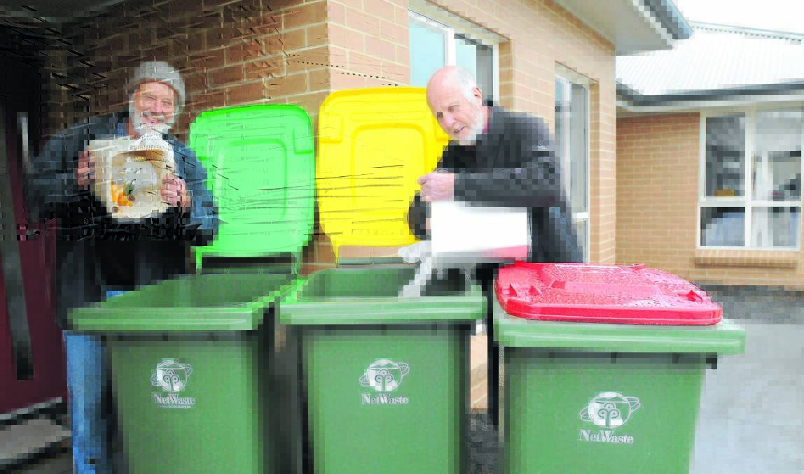 GETTING SORTED: Orange resident Nick King and Orange City councillor Neil Jones utilise small kitchen bins for food scraps (green bin) and recyclable material (yellow bin). Photo: STEVE GOSCH                                                                                                                                                                                               0624sgbins1