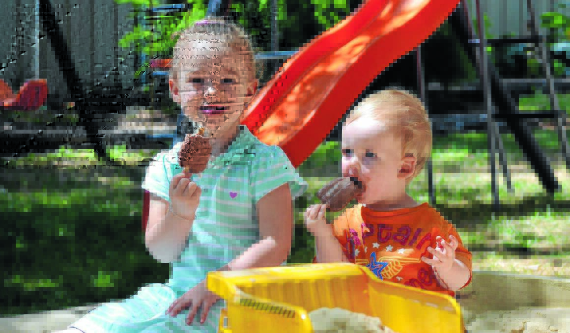 COOL CATS: Ayla and Matthew Daskein swallow chocolate ice blocks in a bid to keep cool yesterday. Photo: NICOLE KUTER                     1231nkweather
