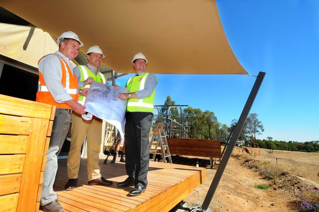 DUBBO: Project manager for the Zoofari Lodge redevelopment at Taronga Western Plains Zoo (TWPZ) Mathew Curran shows TWPZ general manager Matthew Fuller and Dubbo MP Troy Grant design documents. Photo: LOUISE DONGES