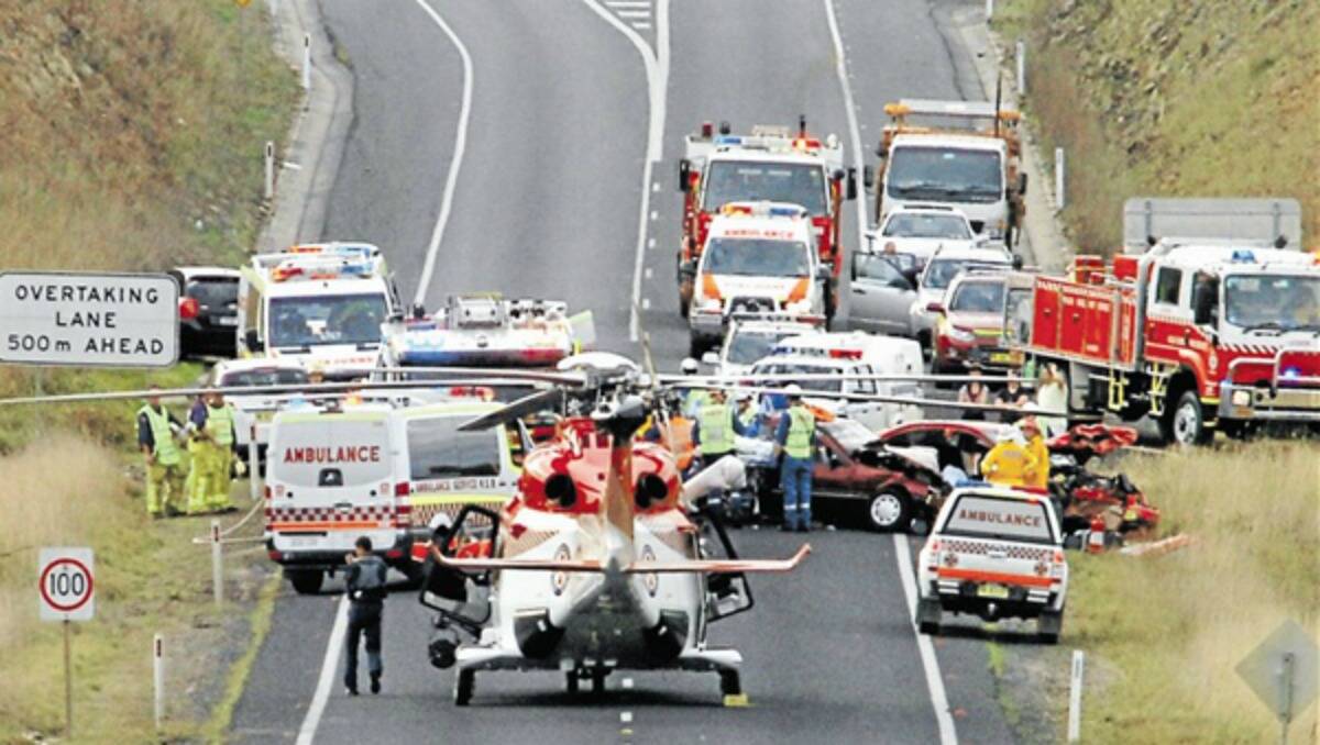 HORROR SMASH: The NSW Ambulance helicopter lands at the scene of yesterday’s crash on the Mitchell Highway east of Orange near the Millthorpe/Blayney turnoff.           Photo: STEVE GOSCH