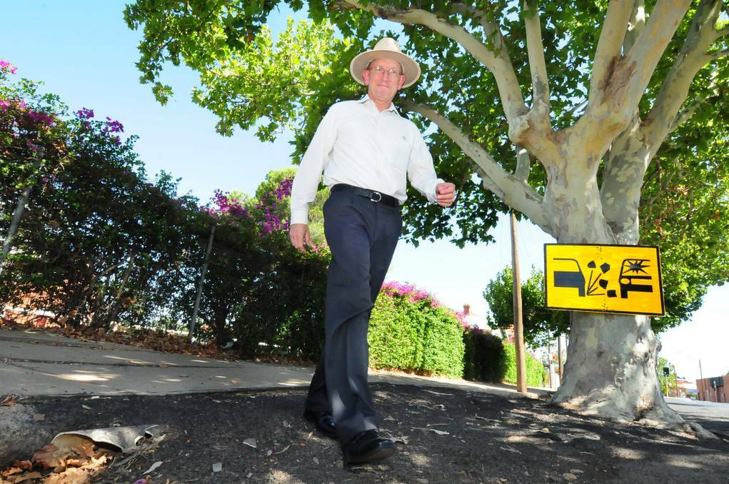 DUBBO: Dubbo City Council acting technical services director Steve Clayton walks along a section of Darling Street damaged by London plane trees. The trees and the makeshift drainage repairs will make way for new underground pipes. Photos: LOUISE DONGES