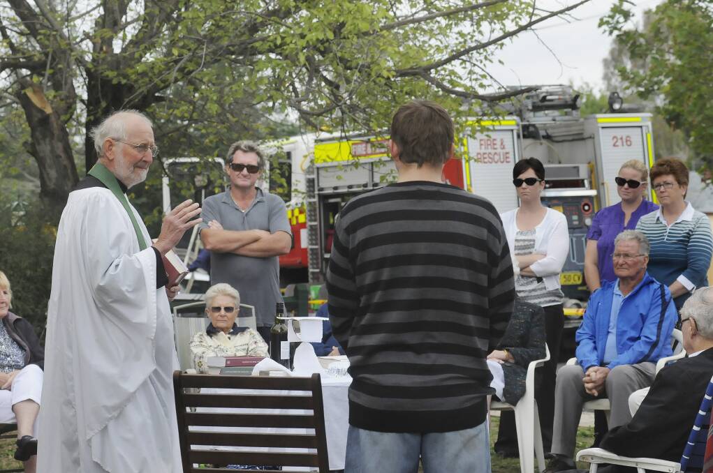 STAY STRONG: Relieving priest Ian Crooks speaks to the congregation at a service next door to the church yesterday. Photo: CHRIS SEABROOK	 022314church1 