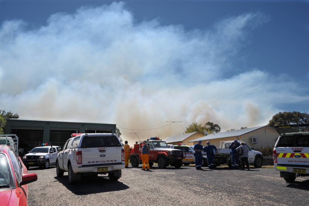 TOO CLOSE FOR COMFORT: Emergency services on the scene at Wattle Flat during Friday’s bushfire emergency. 	013114zfire4