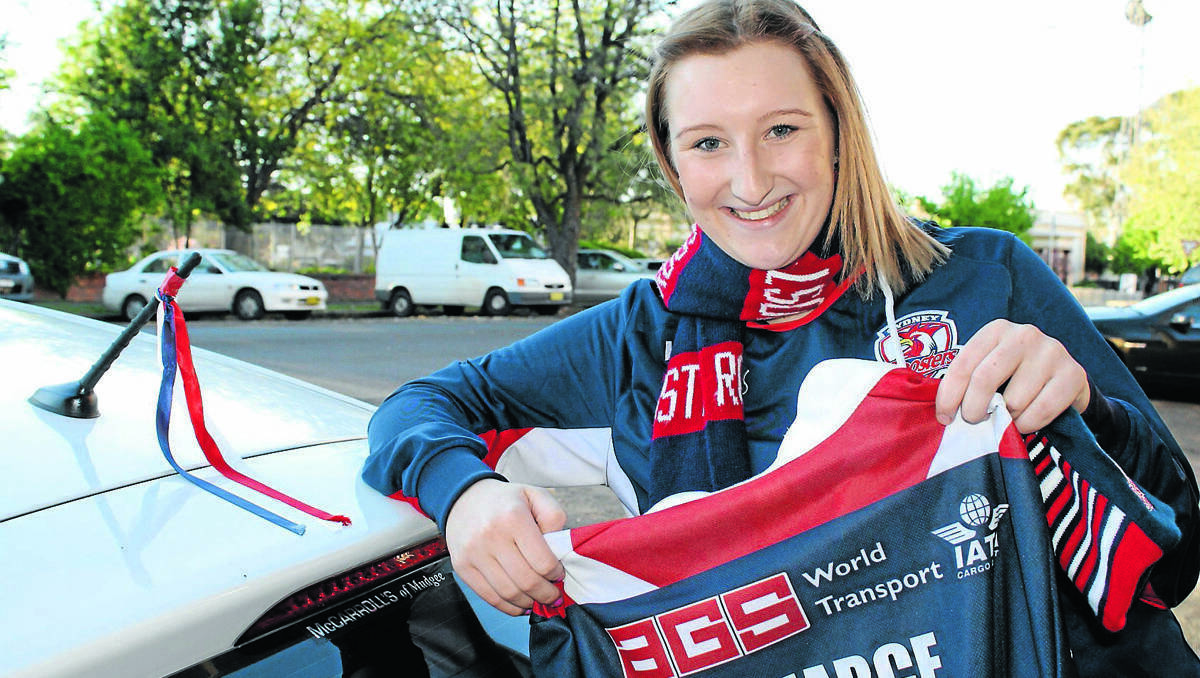 MUDGEE: Bianca Hughes shows her true colours, flying the Roosters colours on her car and proudly showing the jersey signed by her favourite player.