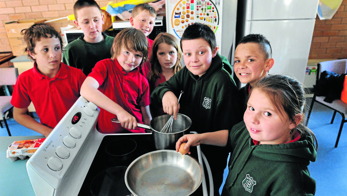 ORANGE: Students of Glenroi Public School are learning basic cooking skills and the importance of nutrition, thanks to dedicated staff. Pictured are (from left) Terry McLean, Rory Bade, Zac Miller, Dylan Jordan, Courtney Bragg, Daniel Walker, Tyren Dixon and Tegan Wood. Photo: STEVE GOSCH 0814sgcook1