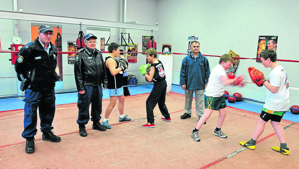ORANGE: Senior Constable Greg Treavors, Senior Constable Helen Baker and boxing trainer Glen Sutherland will offer a new program giving at-risk youths the same opportunities to learn to box as Mitchell Collins, Ben Norris, Damien Johnson and Trent Johnson already have. Photo: JUDE KEOGH 0815pcyc1