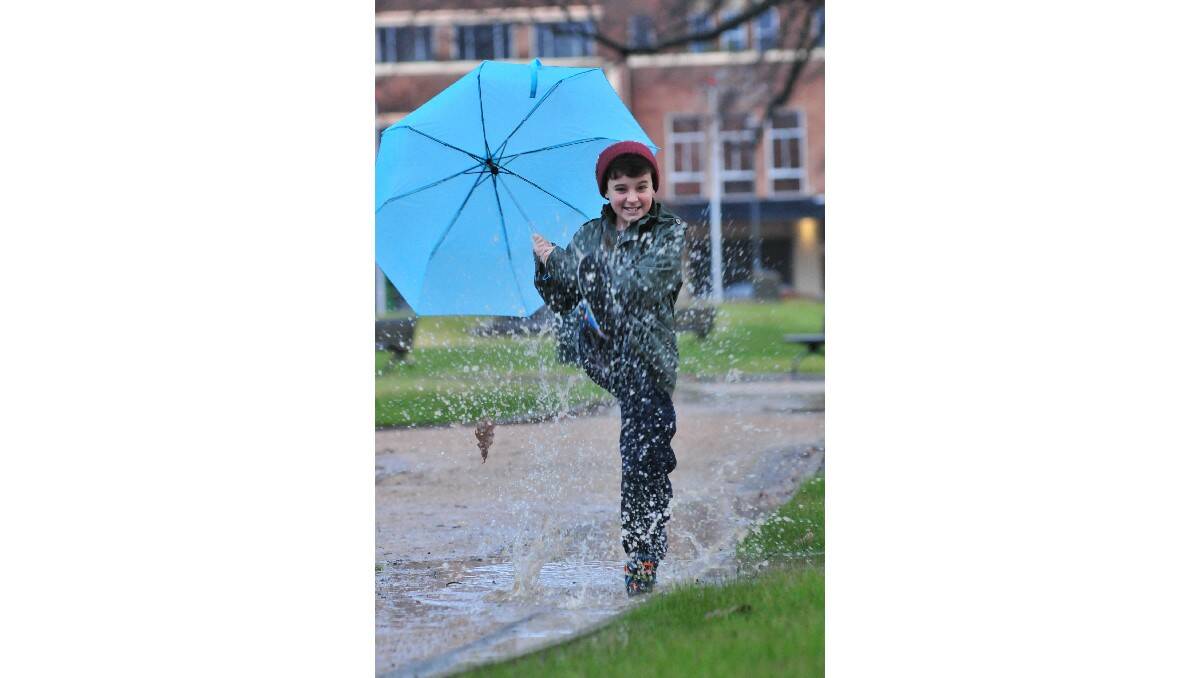 SINGIN’ IN THE RAIN: The weather didn’t dampen Nicholas Collins’s spirits yesterday. Photo JUDE KEOGH              0716rain1
