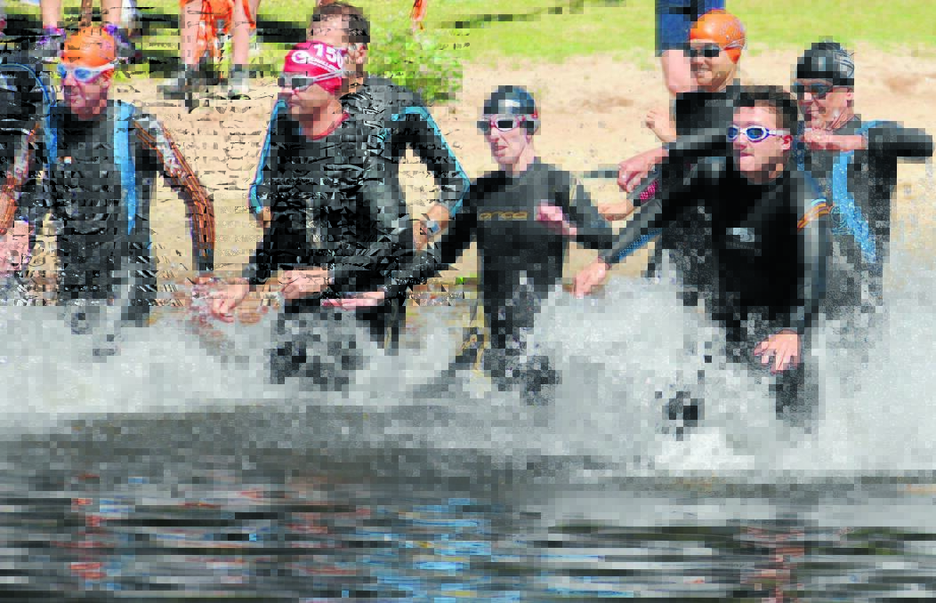 RUBBERY FIGURES: Triathletes hit the water at the lake yesterday. Photo: Steve Gosch