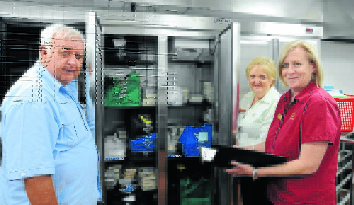 MORE MEALS: Services and Cultural Committee chairman Cr Ron Gander, Food Services’ Sheryl Jenkins and Neighbour Aid’s Jodie O’Sullivan in front of the fully stocked Meals on Wheels fridge. Photo: STEVE GOSCH                                       0117sgmeals1