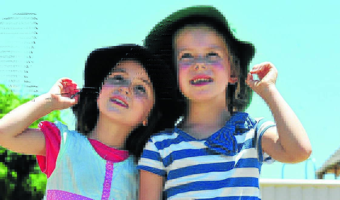 SUN SAFE: Alexandra Ward and Georgie Wishart made sure to put on their hat before heading outdoors in Orange's hot weather yesterday.  Photo: JUDE KEOGH 0130weather1