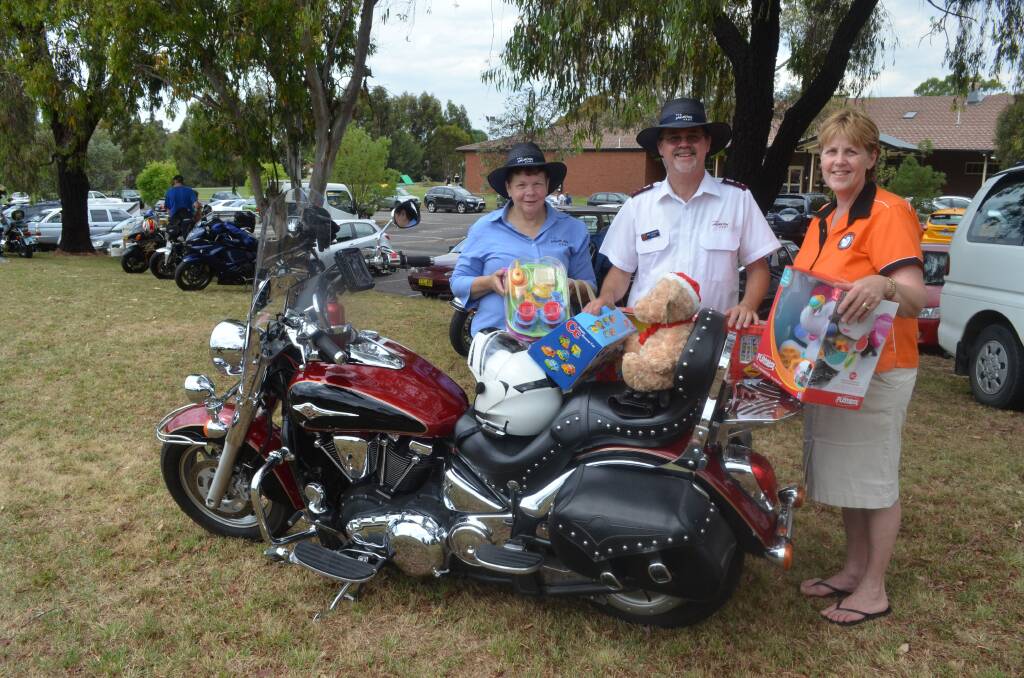 THANKS A MILLION: Delia Davis and captain Greg Saunders from the Salvation Army accepted gifts of toys from Ulysses Bike Club of Orange secretary Karen Fuller at the combined Ulysses and Automotive Enthusiasts Toy Run. Photo: NADINE MORTON                                                                                                   1201nmbike9
