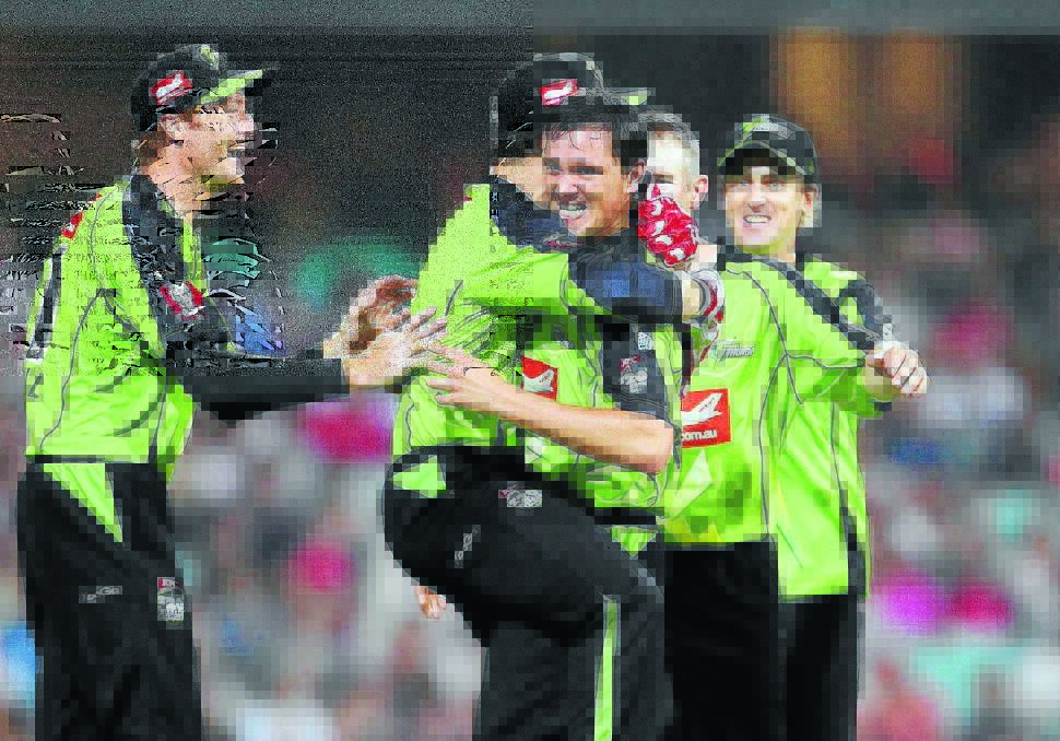 HAPPY: Sydney Thunder’s Chris Tremain celebrates with teammates after getting the wicket of David Warner during the 2013 Big Bash League.