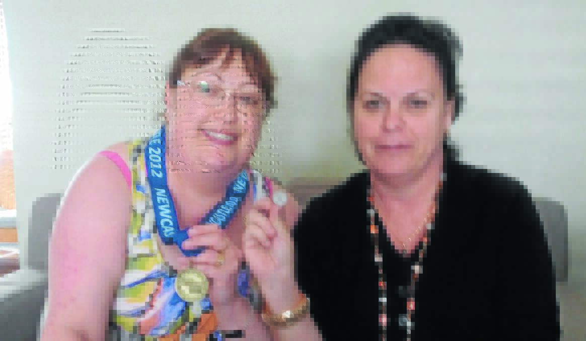 MEDAL VICTORY: Trish Kramer with her gold medal won at the Transplant Games on Monday night for scrabble. Trish is with her support person and old family friend Wendy Anderson who took out the silver pin in the supporter awards category.  