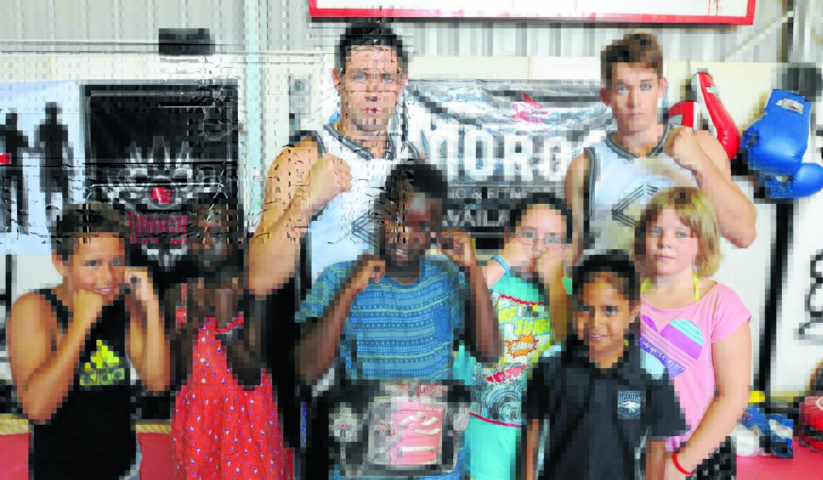 OPPORTUNITY: Michael Whitton, Nyidier Wat, Manyol Kuol (wearing the current WKA super middleweight title belt), Ryan Downie, Tanisha Mundy and Shakyra Carter with Bruce “The Preacher” MacFie and Stix Buckley, during the Merge school holiday program. Photo: STEVE GOSCH                                         0116sgmerge1
