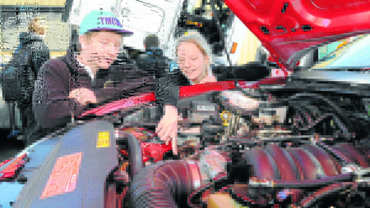 POINT OF INTEREST: Canowindra High School students Michael Ogden and Mellanie Old check out the V8 race car on display at the Central West Careers and Job Expo at the Orange Function Centre. Photo: STEVE GOSCH 0724sgtafe1
