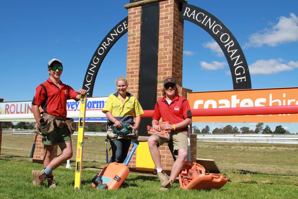 IT’S TOWAC NOT SAND DOWN: Orange tradies Jake Johnston, Tiffany Atkinson and Michael Goodall will enjoy a mix of power tools and races when the annual tradies’ race day hits Towac Park tomorrow.  Photo: Jeff Death 