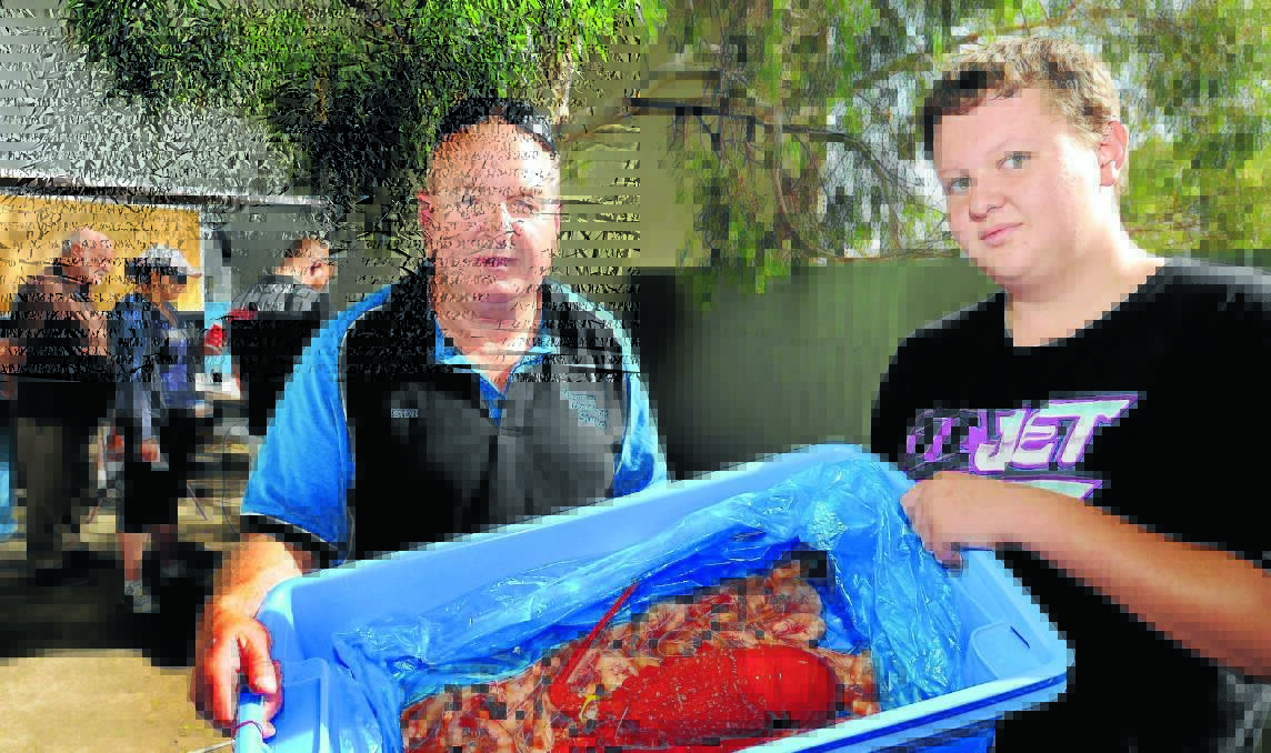A FISHY  CHRISTMAS: Steve Kable and his son Jason, 13, with a rock lobster and prawns which were selling fast for the festive season. Photo: STEVE GOSCH 1224sgfish2