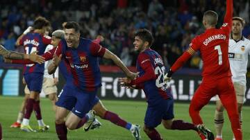 Robert Lewandowski peels away to celebrate one of his three goals in Barcelona's win over Valencia. (AP PHOTO)