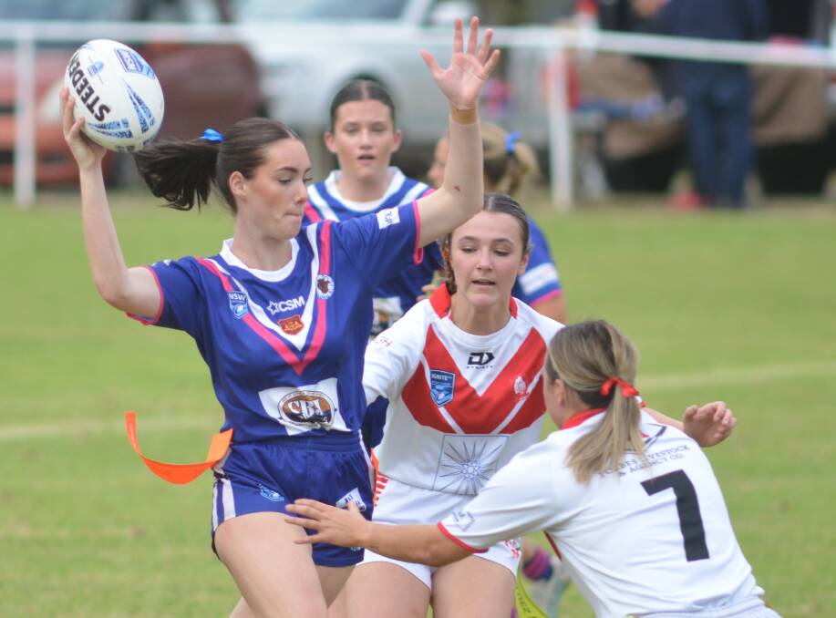 Molong Bullettes player Mia Fraser does her best to evade Manildra Rhinettes defenders. Picture by Dominic Unwin